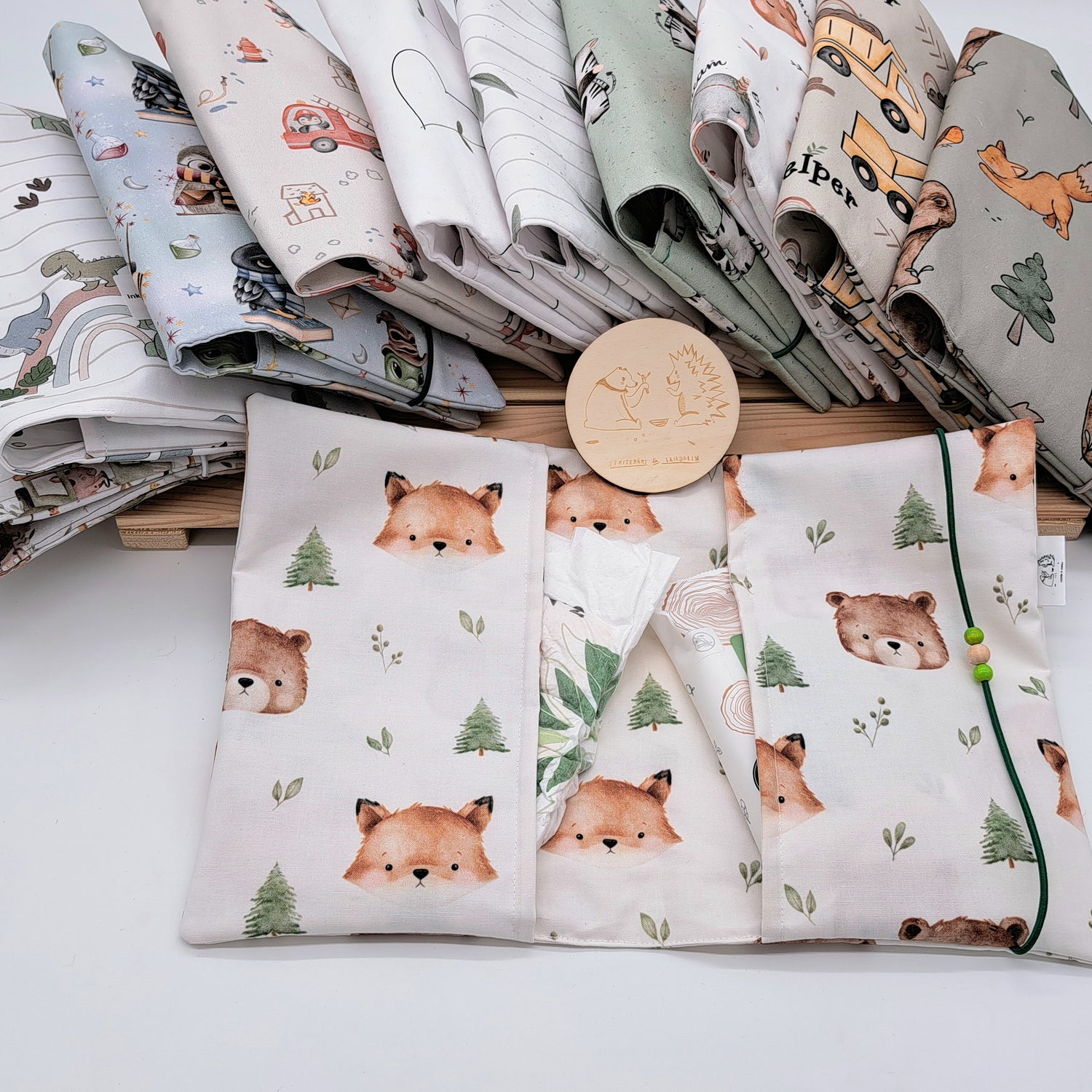 Handgefertigte Windeltasche aus 100% Bio-Baumwolle mit Fach für Windeln und Feuchttücher, Gummikordel-Verschluss mit Holzperlen; nachhaltiges und praktisches Accessoire für Eltern unterwegs.